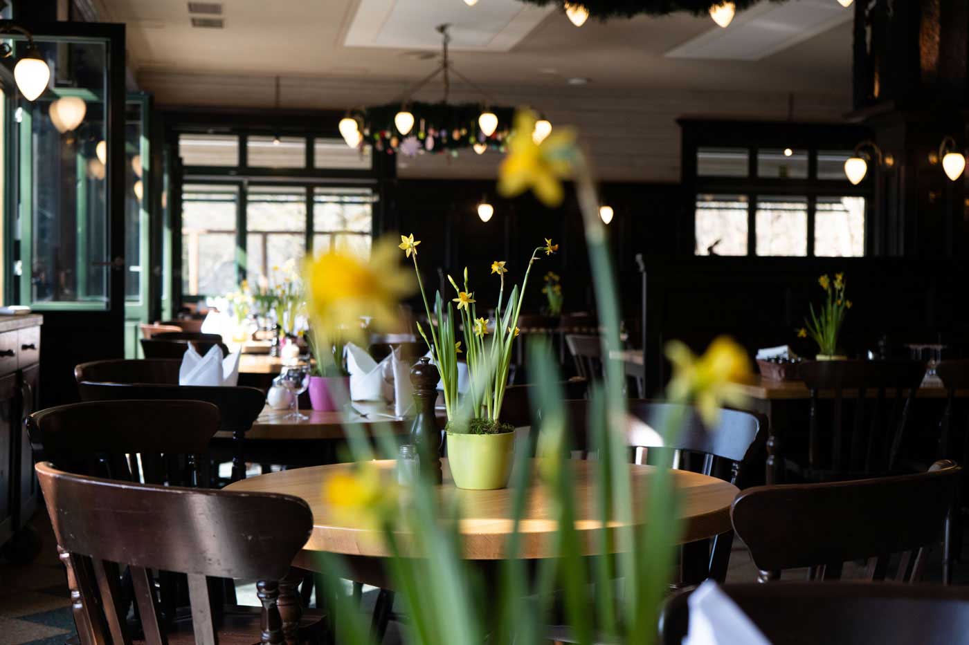 Gedeckter Tisch im Wirtshaus mit Blumen, Kerzen und stilvollem Restaurantambiente.
