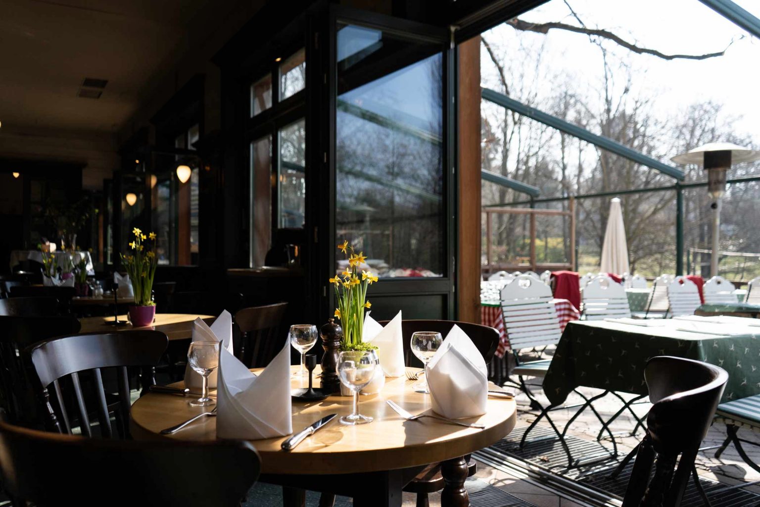 Gedeckter Tisch im Restaurant mit Blick auf Terrasse und See.