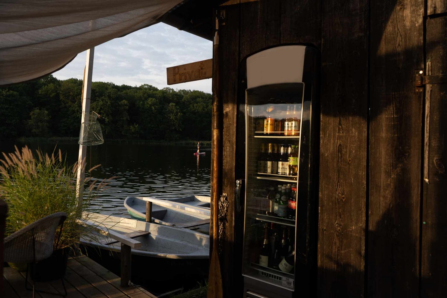 Bootsverleih am See mit Getränkeautomat, Ruderboot und gemütlichem Steg.