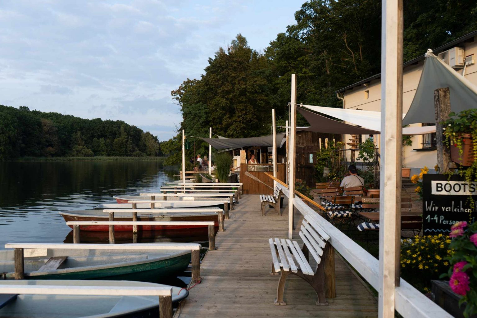 Bootsverleih am See mit Ruderbooten, Steg und Waldkulisse für Ausflüge in der Natur.