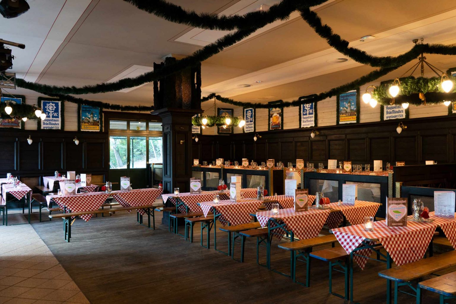 Gemütliches Wirtshaus mit Bierbänken, gedeckten Tischen und klassischer Atmosphäre für Gruppenessen.