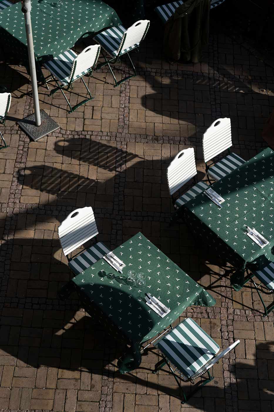 Biergarten-Sitzplätze mit Holztischen und Stühlen auf der Terrasse.