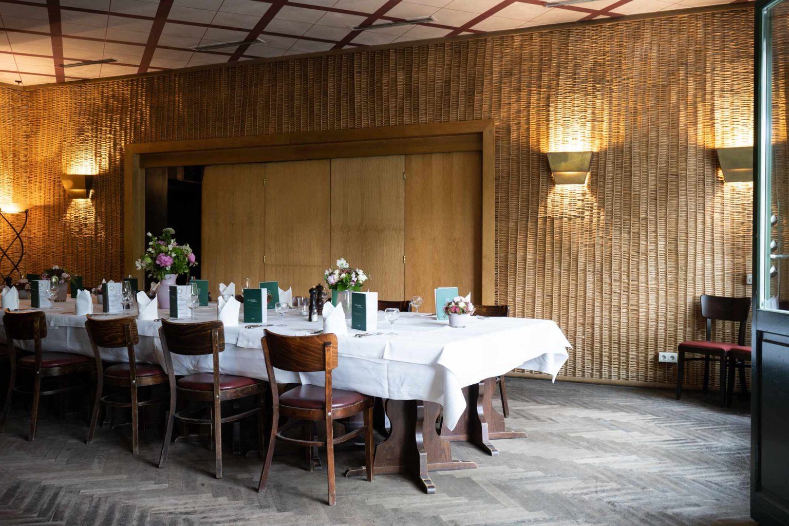 Bar & Lounge mit langer gedeckter Tafel und Holzambiente für Veranstaltungen.