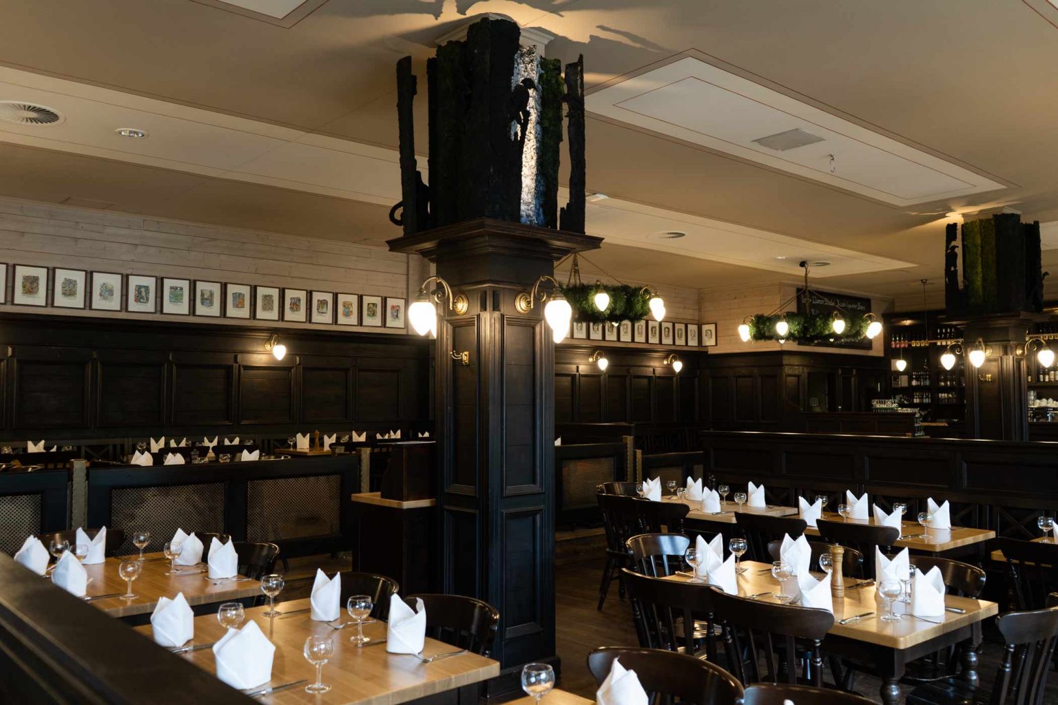 Wirtshaus-Innenraum mit gedeckten Tischen, Holzbänken und gemütlicher Atmosphäre.