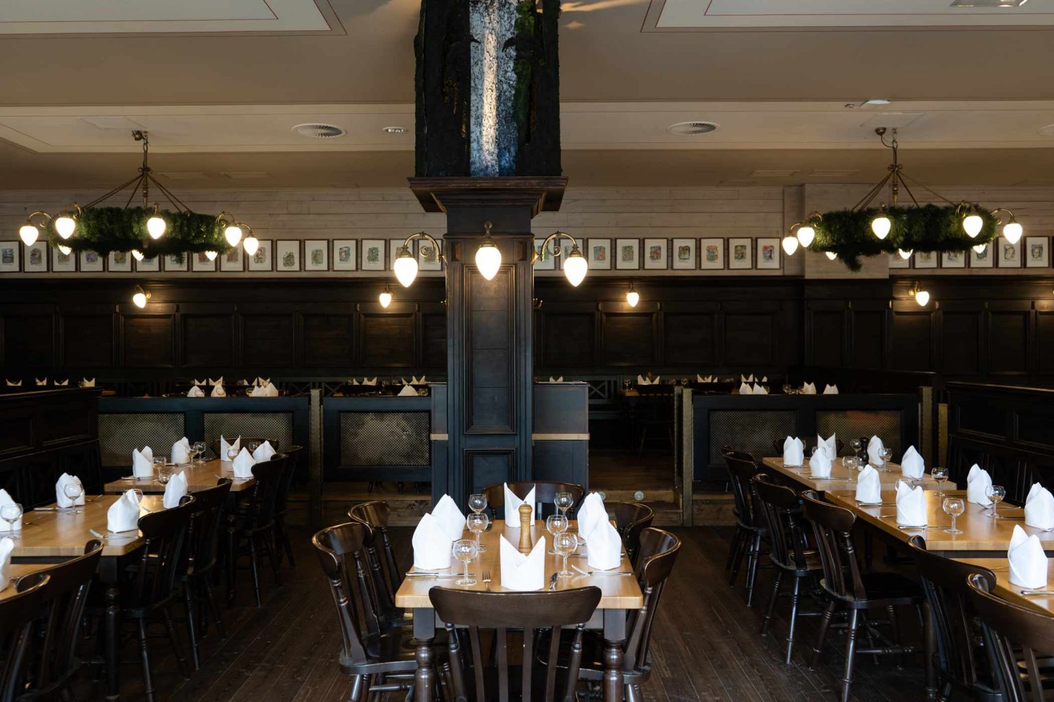 Traditionelles Wirtshaus mit langen gedeckten Tischen und warmem Licht für Feiern und Gruppenessen.