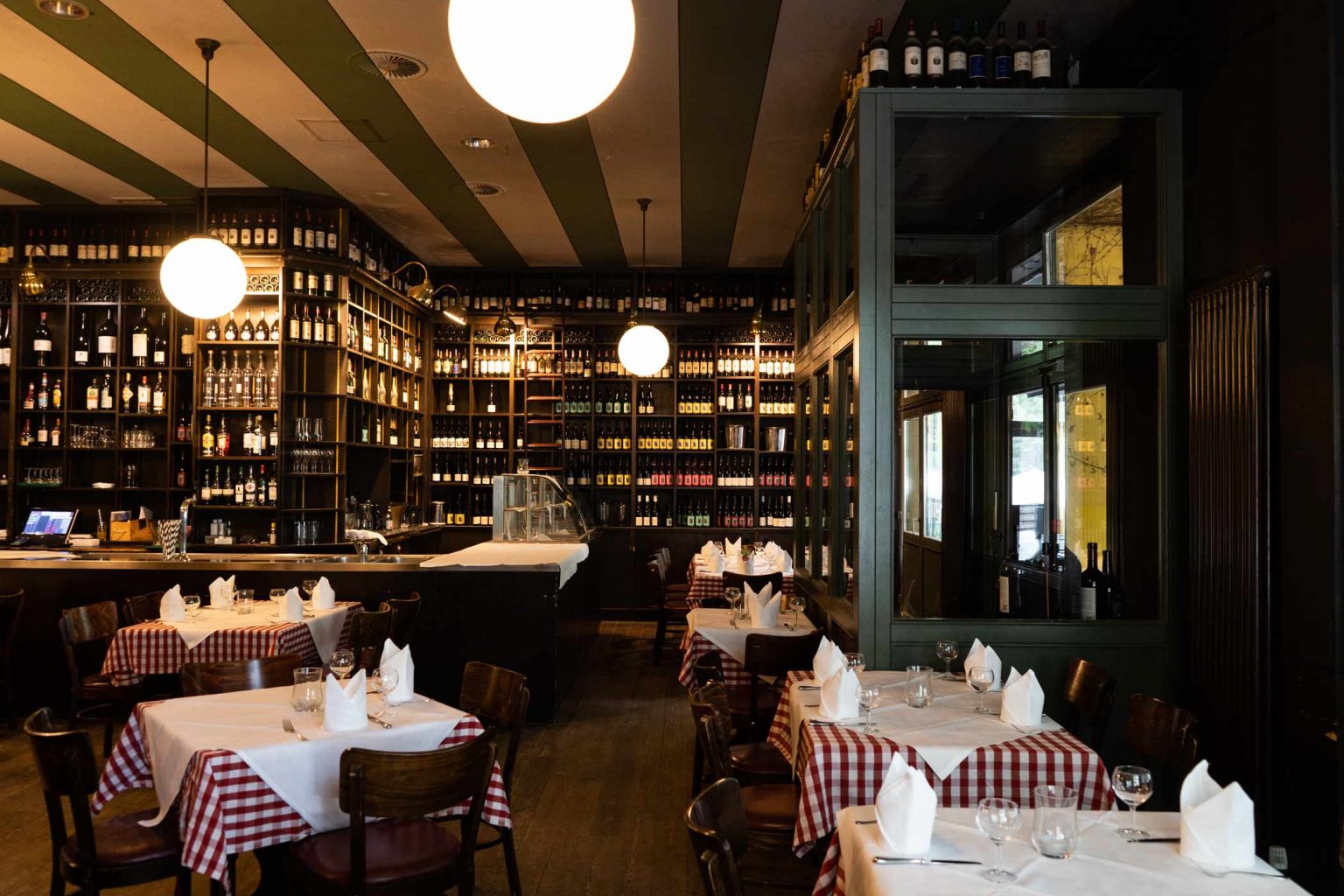 Gedeckter Veranstaltungsraum mit Bar, Weinregalen und gemütlichem Restaurantambiente.