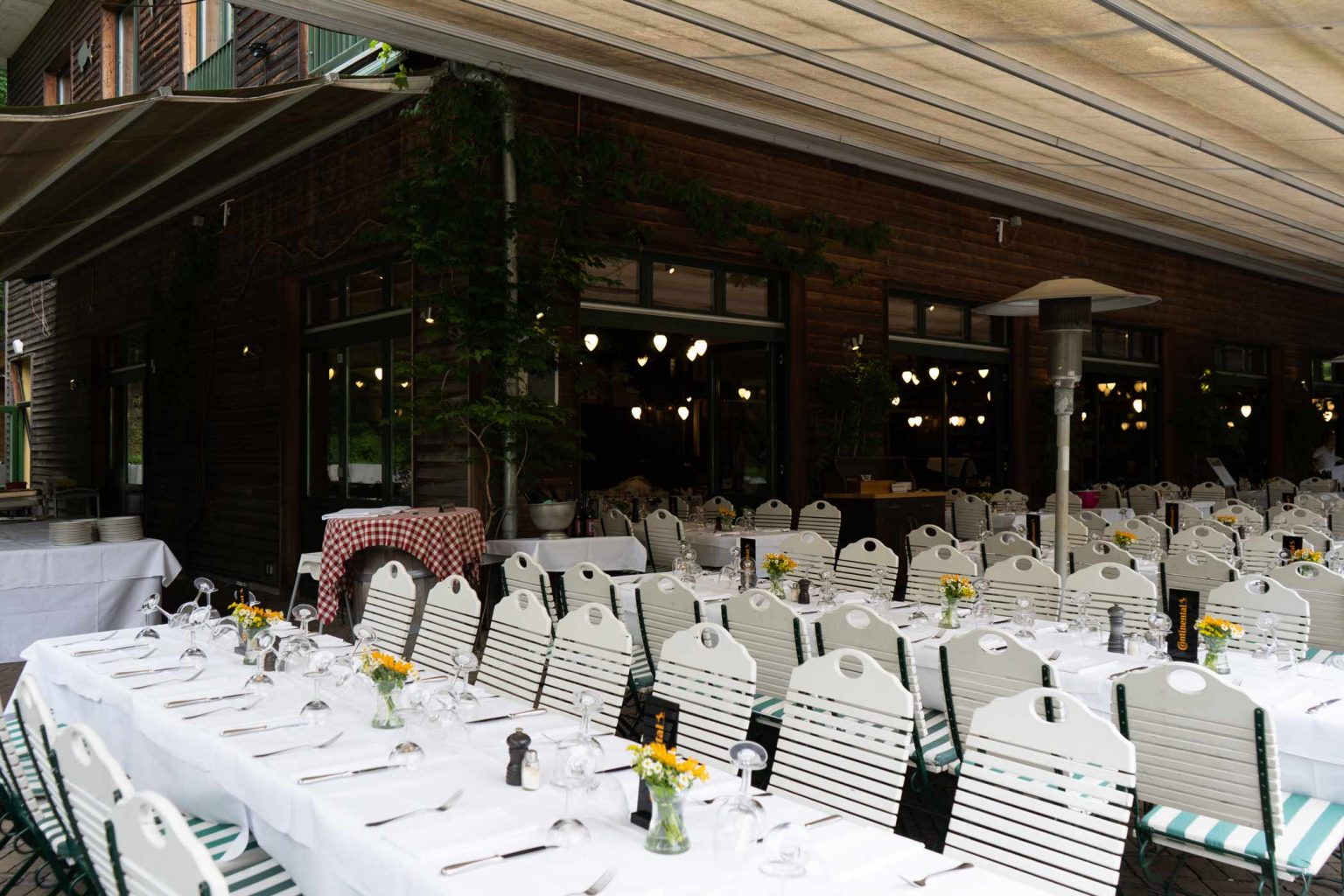 Überdachte Terrasse mit festlich gedeckten Tischen für Feiern und Veranstaltungen.