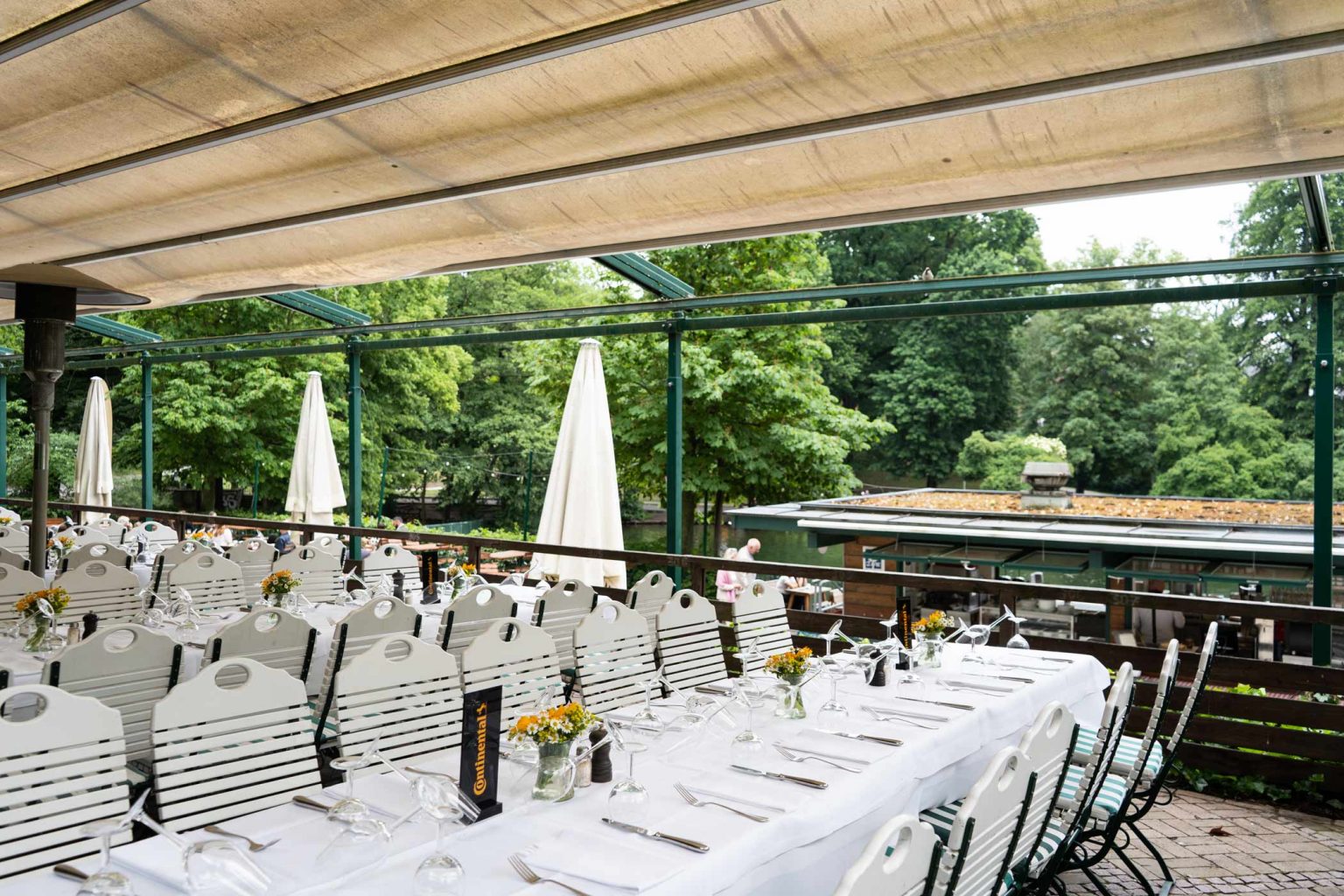 Festlich gedeckte Terrasse mit langen Tafeln für Hochzeiten, Feiern und Events.