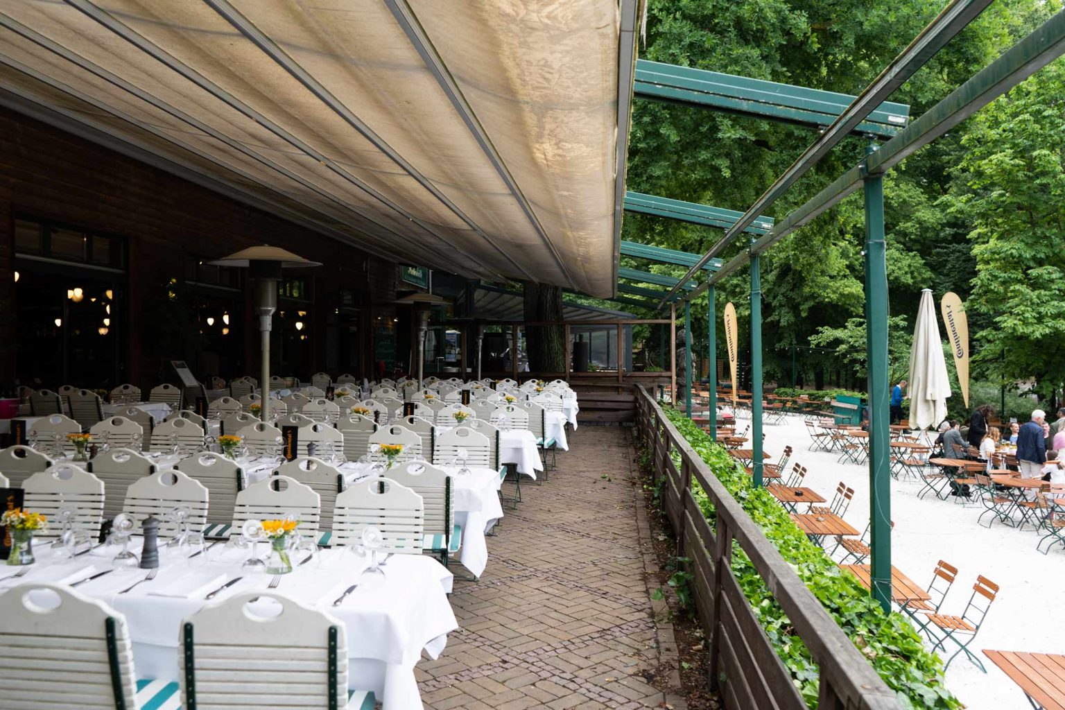 Überdachte Wirtshaus-Terrasse mit festlich gedeckten Tischen für Feiern und Veranstaltungen.
