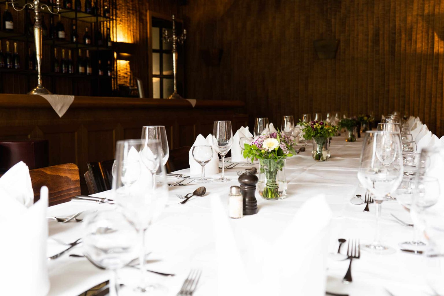 Festlich gedeckte Tische in der Bar & Lounge mit Blumendekoration für Hochzeiten und Feiern.