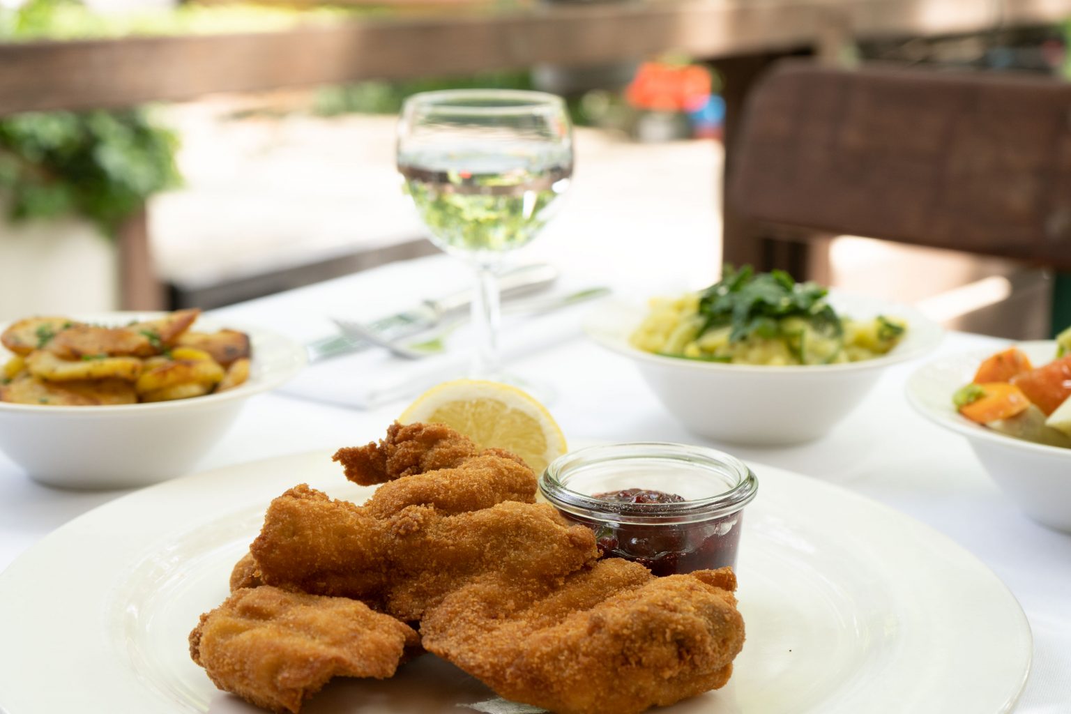 Knuspriges Fleischgericht mit Beilage auf weißem Teller im Wirtshaus.