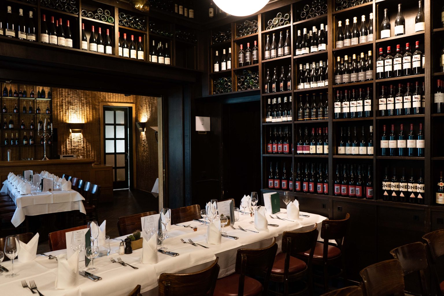 Gedeckte Tafel in der Lutter & Wegner Weinhandlung mit Weinregalen und stilvollem Ambiente.
