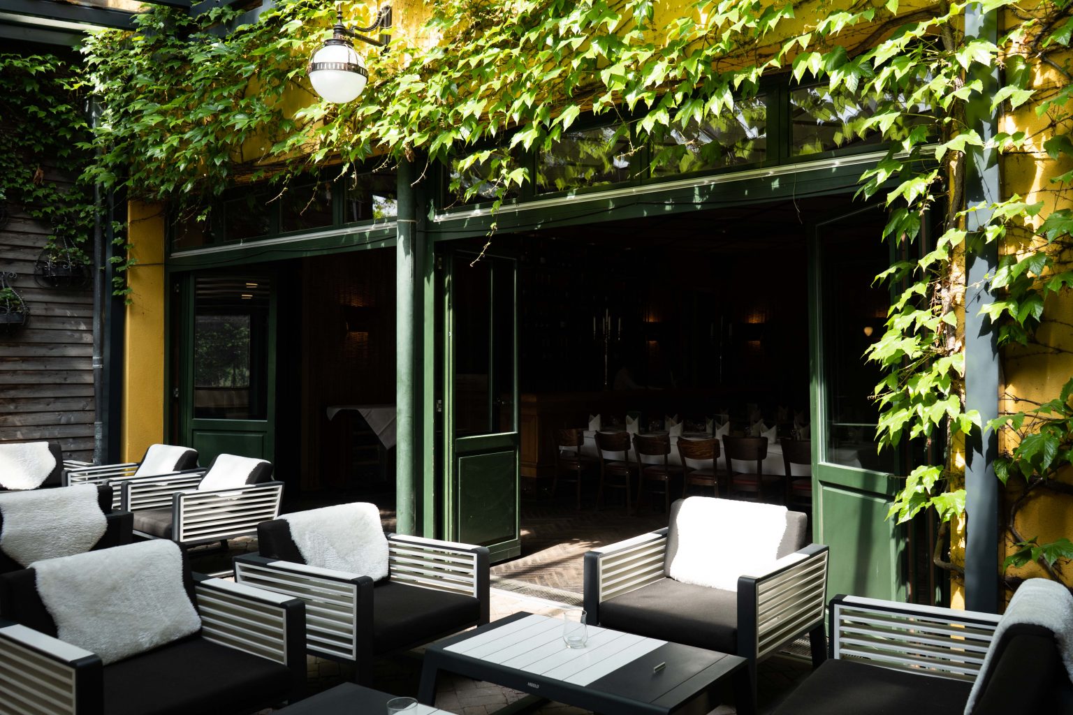 Überdachte Lounge-Terrasse mit modernen Sitzmöbeln für Gäste und private Feiern.