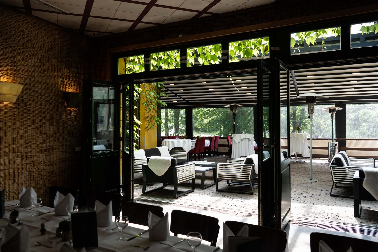 Heller Restaurantbereich mit gedeckten Tischen und Blick auf die Terrasse für Feiern und Events.
