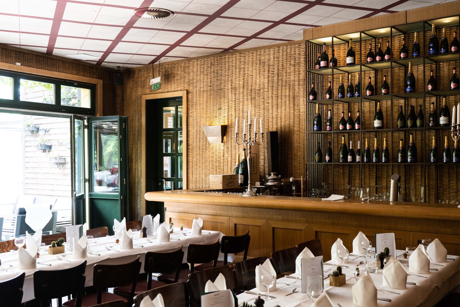 Gemütliche Bar & Lounge im Restaurant mit gedeckten Tischen, Holzambiente und großer Weinauswahl.