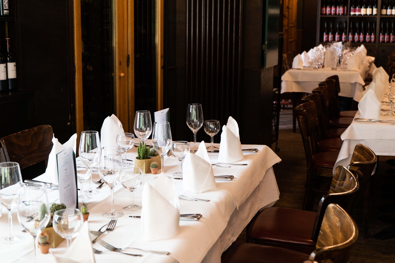 Festlich gedeckter Tisch mit weißen Servietten und Weingläsern für private Feiern.