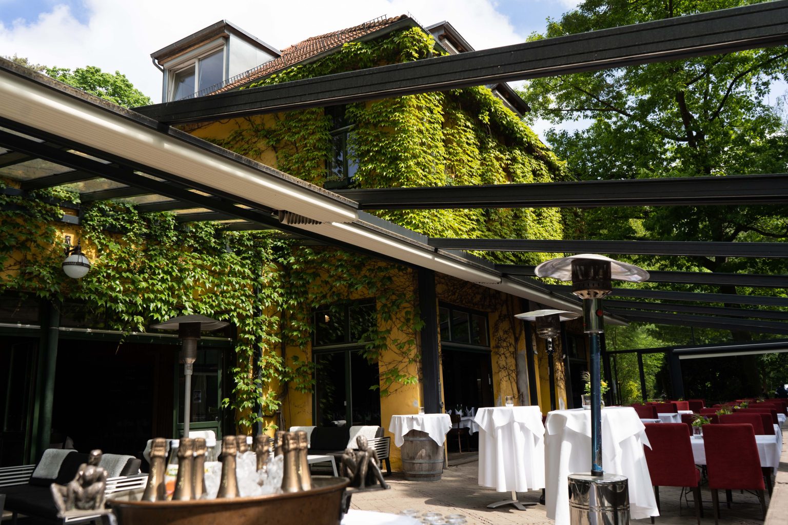 Überdachte Terrasse für Feiern und Events mit gedeckten Tischen im Grünen.