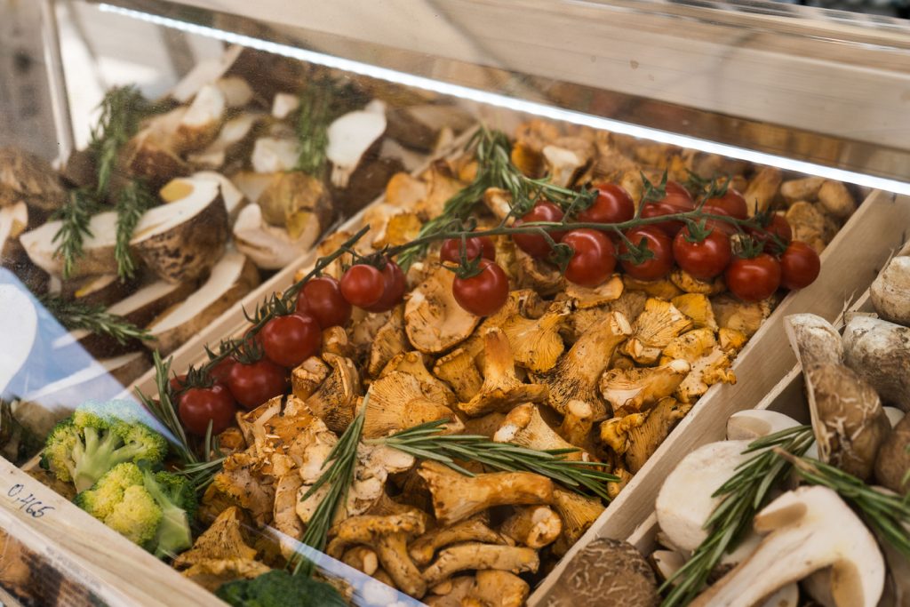 Antipasti- und Gemüseauswahl mit Pilzen, Tomaten und frischen Kräutern für Buffet oder Catering.