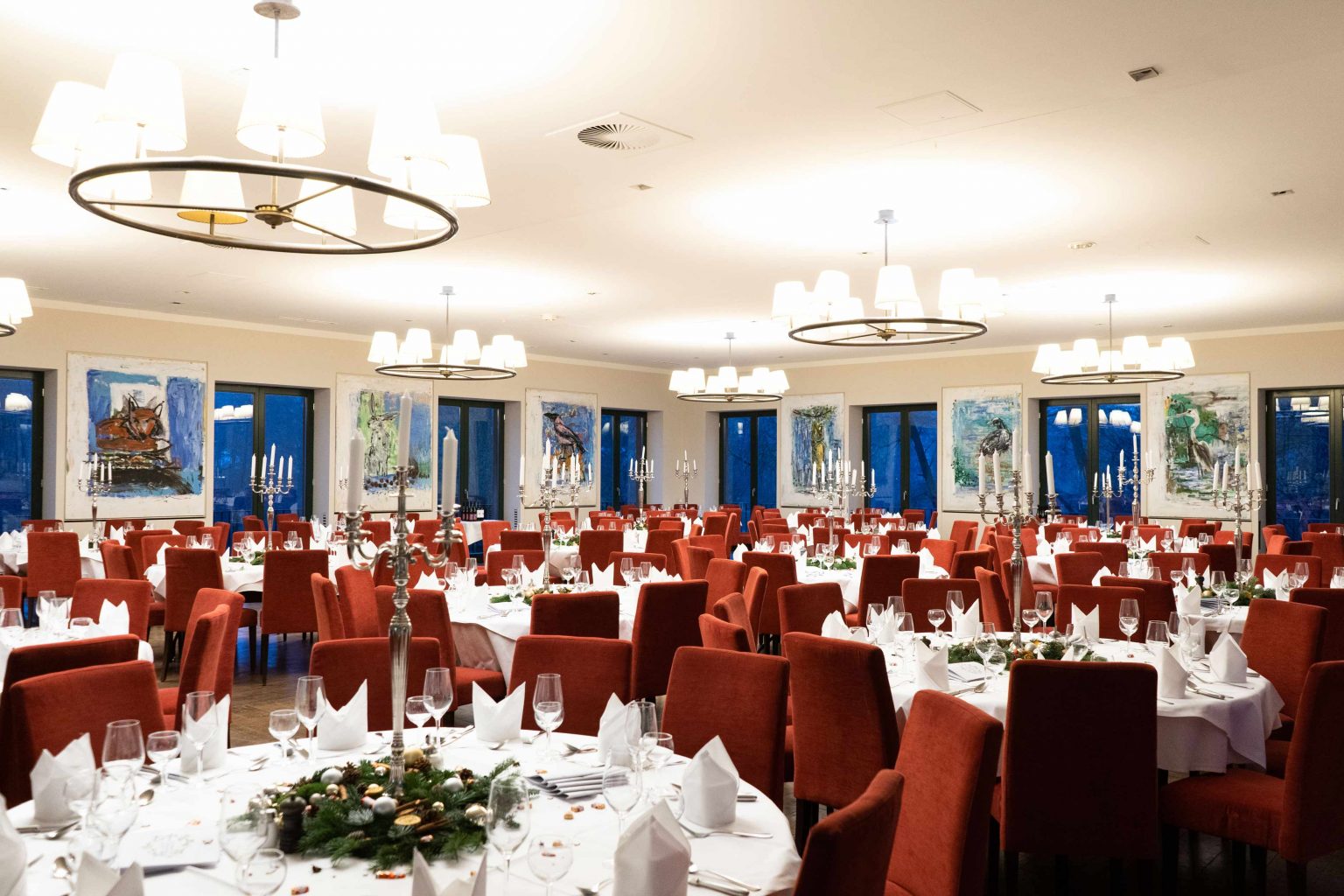 Großer Festsaal mit festlich gedeckten Tischen für Weihnachtsfeiern und Veranstaltungen.