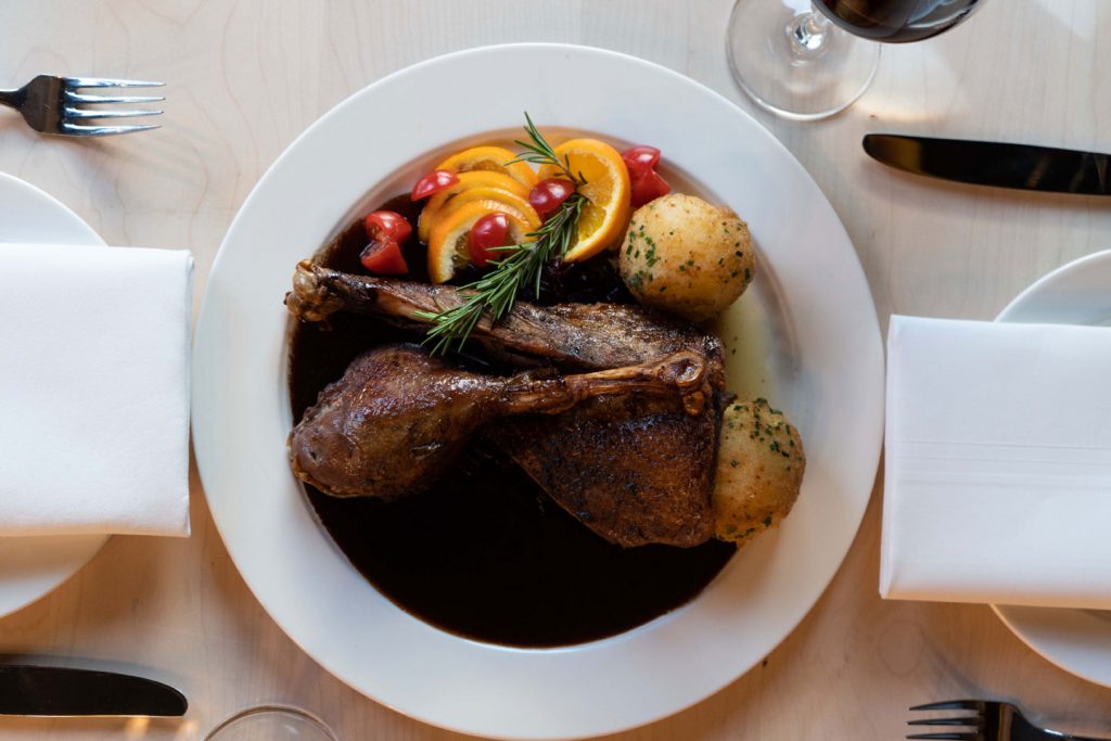 Geschmortes Fleischgericht mit Kartoffeln, Gemüse und dunkler Sauce im Restaurant.